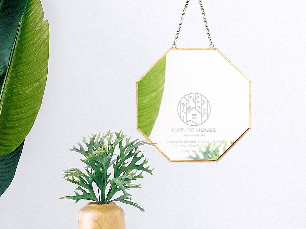 ロゴ刻印が施されたステンレス製キャッシュトレイと八角形ミラーのアップ。清潔感と高級感のあるレジ周りの必需品