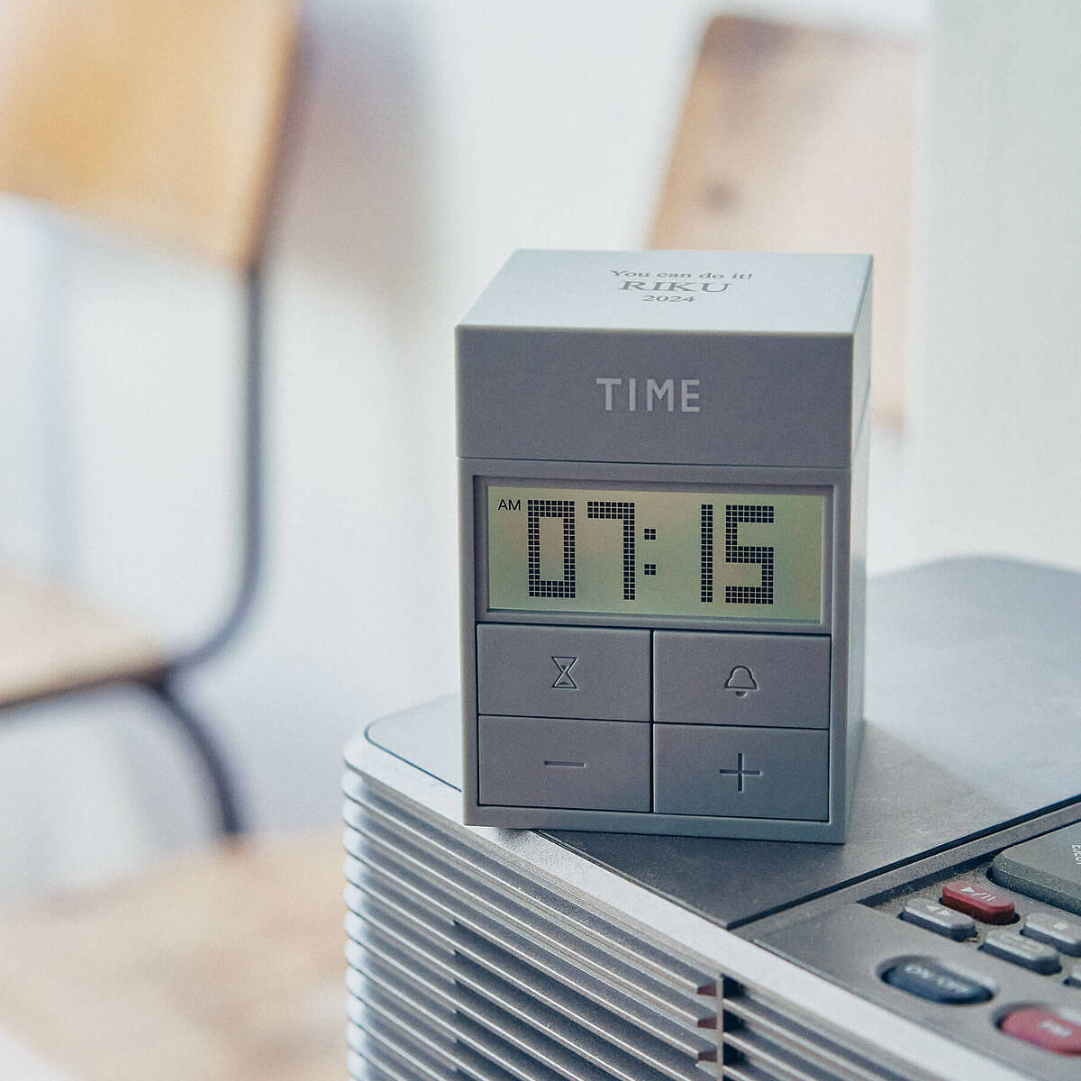 落ち着いたグレーカラーでインテリアに馴染む、名入れアラームクロック(目覚まし時計)。天面にメッセージを刻印。中学生の自立を促すギフト。
