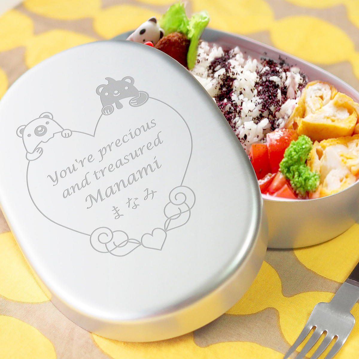 丈夫で保温庫にも対応したシンプル構造のアルミ製お弁当箱。蓋には精密な刻印が施されている。