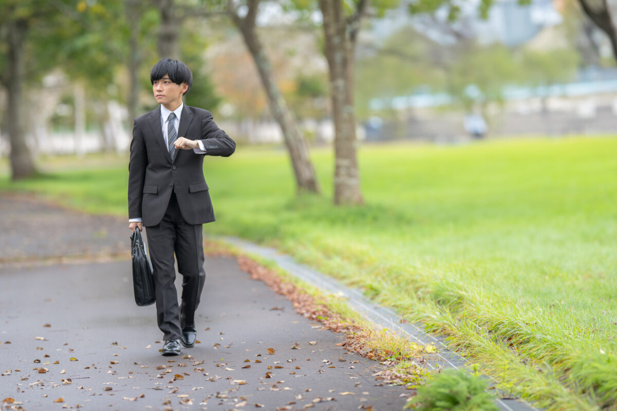 4月の新生活に期待を膨らませスーツで歩く新社会人の男性。就職祝いや新しい門出を象徴するイメージ