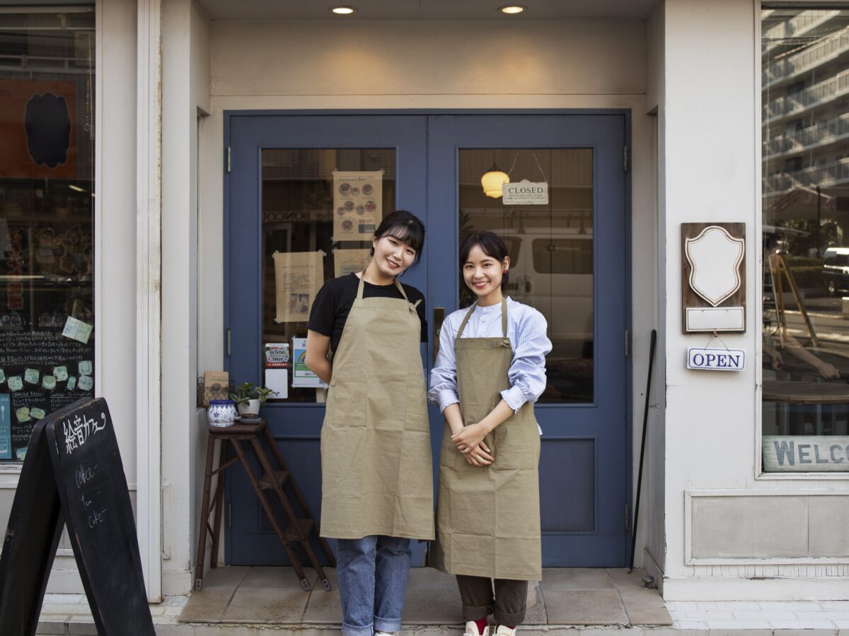 新しくオープンするケーキショップで開店準備をする女性オーナーたち。開店祝いや開業の喜びと期待を象徴するイメージ