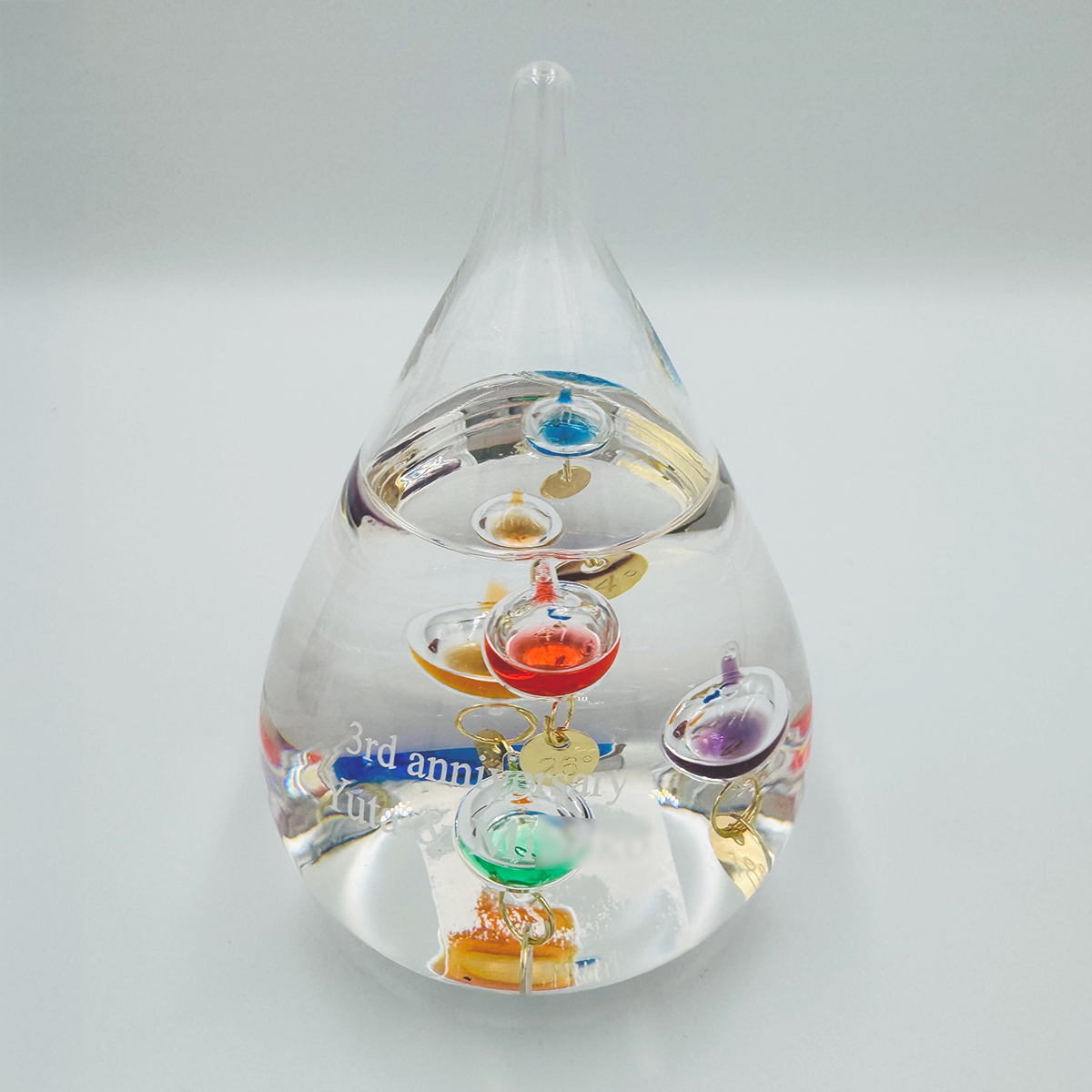 横浜市のK様よりオーダーいただいた、初節句お祝いの名入れガリレオ温度計。ガラス表面に記念のメッセージを美しく刻印した実例画像。