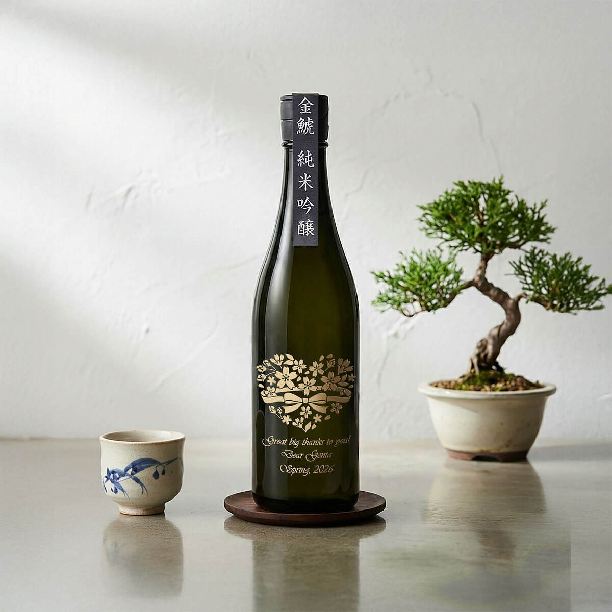 日本酒「金鯱 純米吟醸」のボトルに職人が手作業で施した、敬老の日を祝う鯛のイラストと名前のオリジナル名入れ刻印のクローズアップ写真